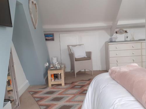 a bedroom with a bed and a dresser and a chair at The Bridges B&B in Broomhill