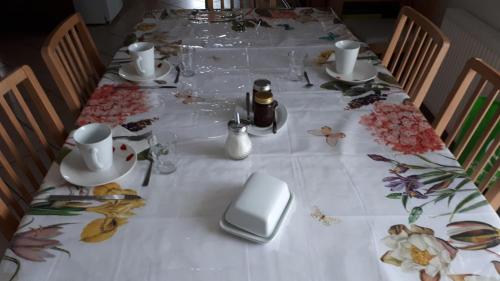 une table avec une nappe blanche avec des fleurs dessus dans l'établissement Jazz et Vacances, à Monlezun
