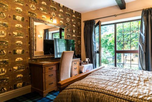 a bedroom with a bed and a dresser with a mirror at The Mews Hotel in Wakefield