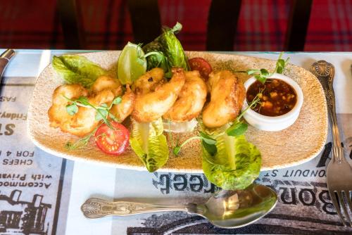 a plate of shrimp and vegetables on a table at The Mews Hotel in Wakefield