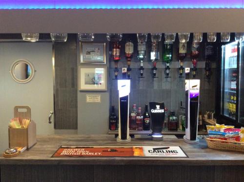 a bar with bottles of alcohol on a wall at Brene Hotel in Blackpool