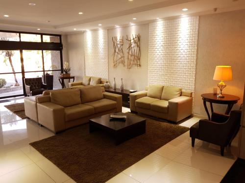 a living room with couches and a coffee table at Hotel Cristal Rio Claro in Rio Claro