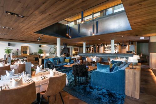 a restaurant with blue couches and tables at ZillergrundRock Luxury Mountain Resort in Mayrhofen