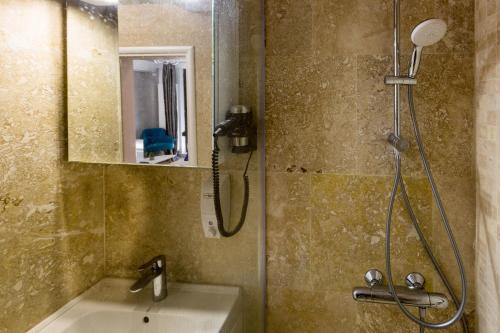 La salle de bains est pourvue d'une douche, d'un lavabo et d'un miroir. dans l'établissement Solid Residence, à Mamaia
