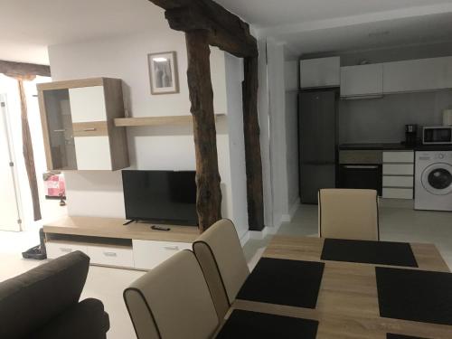 a living room with a television and a table and chairs at Castro Sun And Beach in Castro-Urdiales