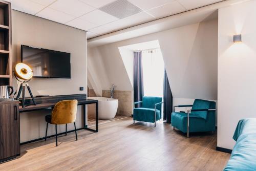 a room with a desk and chairs and a tub at Hotel Hoogeveen in Hoogeveen