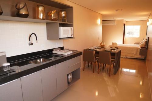 a kitchen with a sink and a table with chairs at Forte Express in Macapá