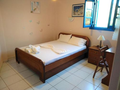 a small bedroom with a bed with towels on it at Mouragio Studios in Tyros