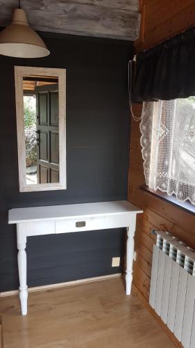 a white bench in a room with a mirror at Chata Starych Znajomych in Sanok