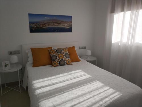 een slaapkamer met een bed met oranje kussens bij Oliva Home in Los Cristianos