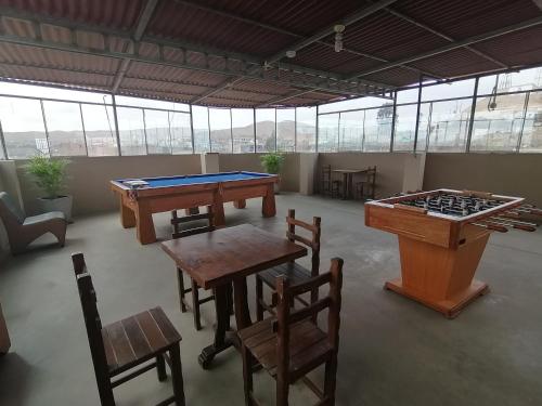a room with two ping pong tables and a billiard table at Hotel Roussean in San Vicente de Cañete