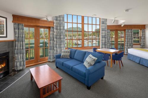 a living room with a couch and a bed and a fireplace at Canadian Princess Lodge & Marina in Ucluelet