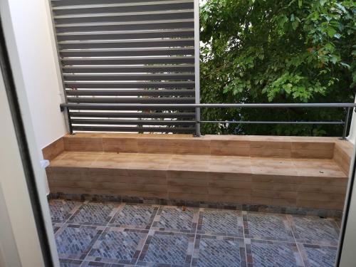 d'un balcon avec un banc en bois et une clôture. dans l'établissement F2 PARC TRINITE, à Saint-Denis