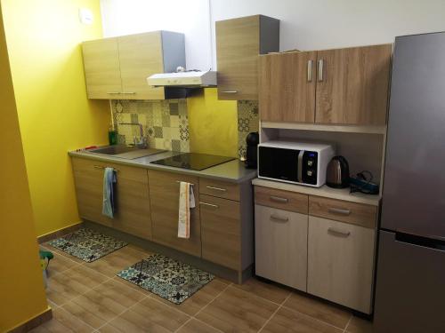 - une petite cuisine avec des placards en bois et un four micro-ondes dans l'établissement F2 PARC TRINITE, à Saint-Denis