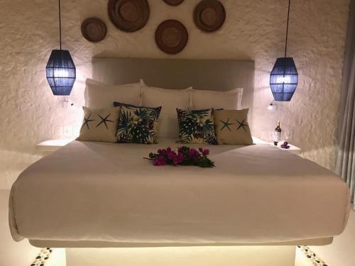 a bedroom with a large white bed with flowers on it at Soho Boutique Holbox - Adults Only in Holbox Island