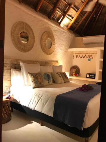 a bedroom with a large bed with white sheets and pillows at Soho Boutique Holbox - Adults Only in Holbox Island