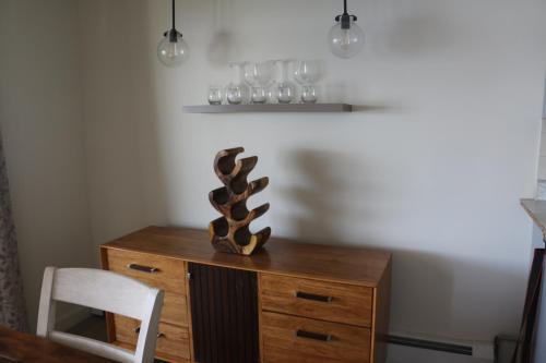 a wooden desk with a chair and a vase on it at Lakeshore Vermont in Colchester