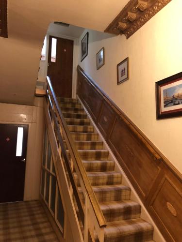 a stairway in a home with a wooden staircase at The Purple Tree Guest House in Torquay