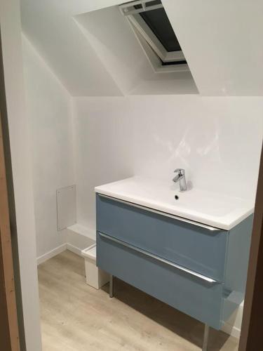 - un lavabo dans la salle de bains avec une commode bleue dans l'établissement Gite Bord de Mer 80 m2, à Bernières-sur-Mer