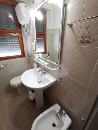 a bathroom with a sink and a toilet and a mirror at Hotel Calgary in Casalbordino
