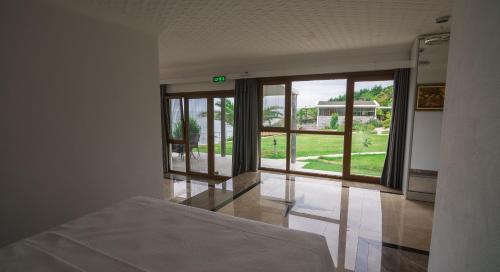 a bedroom with a bed and a view of a yard at Palm Beach Şile Villa Hotels in Istanbul