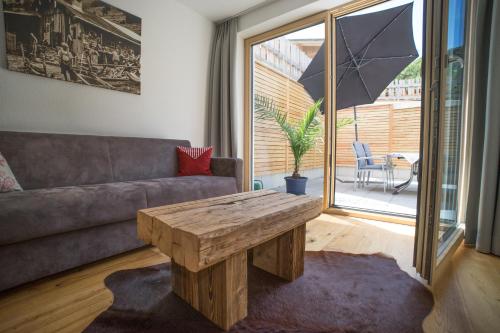 a living room with a couch and a wooden coffee table at Alpenzeit in Ladis