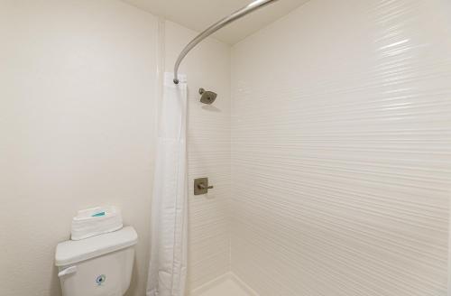 a white bathroom with a shower and a toilet at Lux Verde Hotel in Cottonwood