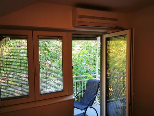 a room with three windows and a chair on a balcony at CENTRAL PARK SOKOBANJA in Soko Banja