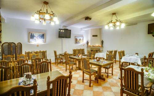 a restaurant with tables and chairs in a room at Готельний комплекс Парламент, Яблуниця in Yablunytsya