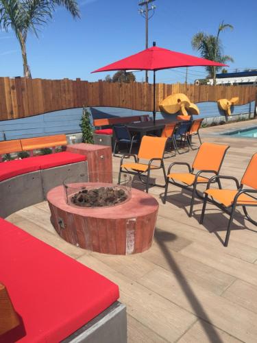 a patio with chairs and tables and a fire pit at Beach Street Inn and Suites in Santa Cruz