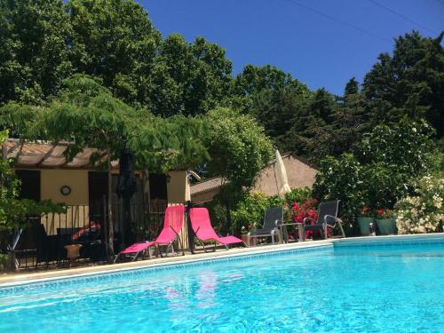 - un groupe de chaises roses et une piscine dans l'établissement LANQUEDOC VILLA - L'AMANDIER, à Cazouls-d Herault