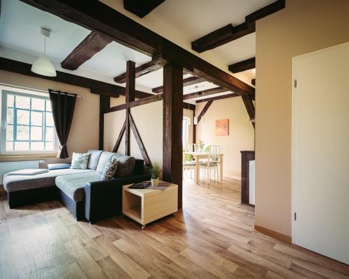 una sala de estar con un sofá y una mesa en Ferienwohnungen an der Wassermühle, en Quedlinburg