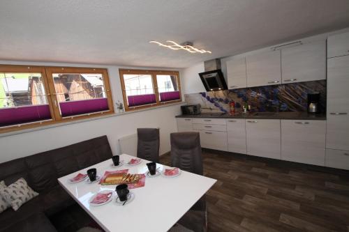 eine Küche mit einem weißen Tisch und Stühlen in einem Zimmer in der Unterkunft Haus Sonnenhang in Sölden