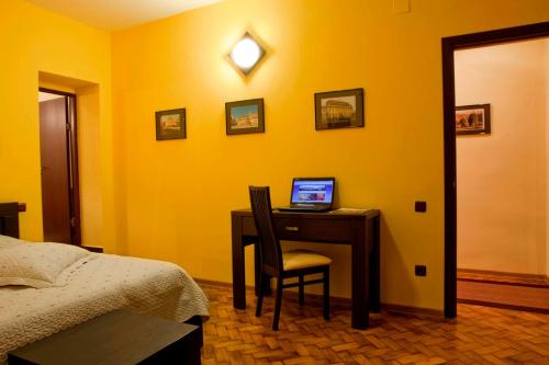 a bedroom with a desk with a laptop computer on it at Rami House central double rooms in Braşov