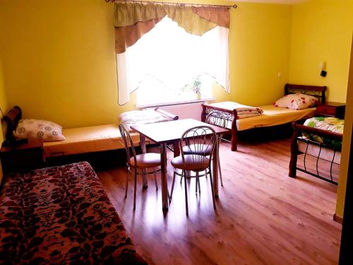 a room with a table and chairs and a window at Gospodarstwo Agroturystyczne Pod Lasem Maria Płazio in Narol