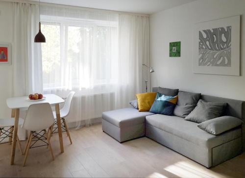 a living room with a couch and a table at Green leaf apartments in Liepāja