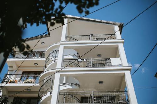 a white building with balconies on the side of it at Apartments ANA Karlobag in Karlobag