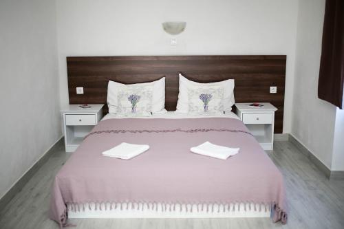 a bedroom with a large bed with two white tables at Apartments ANA Karlobag in Karlobag