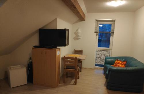 ein Wohnzimmer mit einem TV, einem Sofa und einem Tisch in der Unterkunft Inseldorf Wardt in Xanten