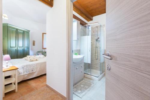 uma casa de banho com uma cama, um chuveiro e um lavatório. em B&B La Vela Chia em Chia