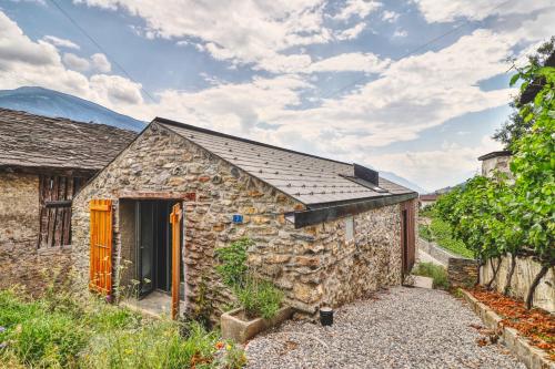 a stone house with a slate roof and a driveway at Renovated historic barn in mountain village in Ollon