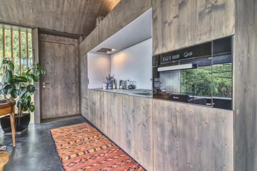 cocina con paneles de madera en las paredes y encimera en Renovated historic barn in mountain village, en Ollon