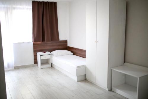 a small room with a white bed and a window at Apartments ANA Karlobag in Karlobag
