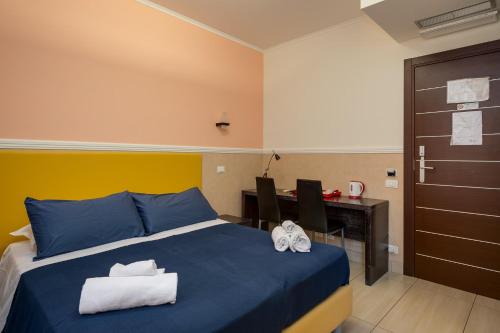 a bedroom with a blue bed and a desk with a computer at Mocenigo Vatican Suites in Rome