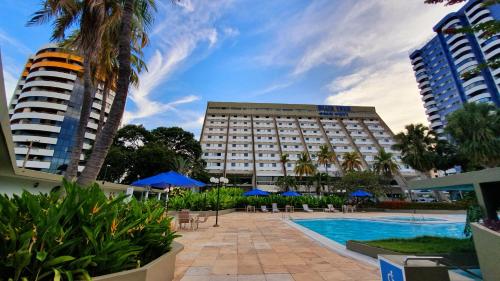 a hotel with a swimming pool in front of a building at Blue Tree Towers Rio Poty in Teresina