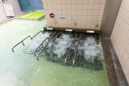 a pool of water in a bathroom with foam at Sauna & Capsule AMZA (mens only) in Osaka