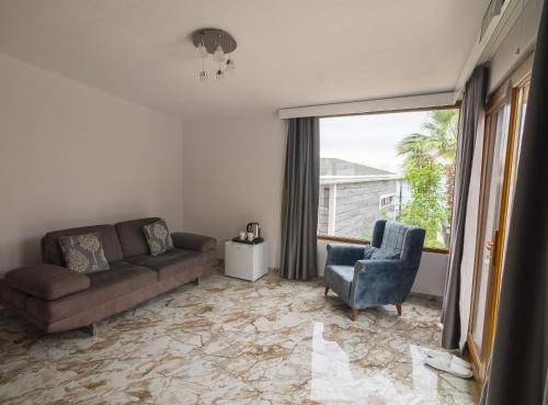 a living room with a couch and a chair and a window at Palm Beach Şile Villa Hotels in Istanbul
