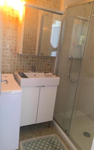 une salle de bain avec un lavabo et une douche dans l'établissement boulhome, à Boulouris-sur-Mer
