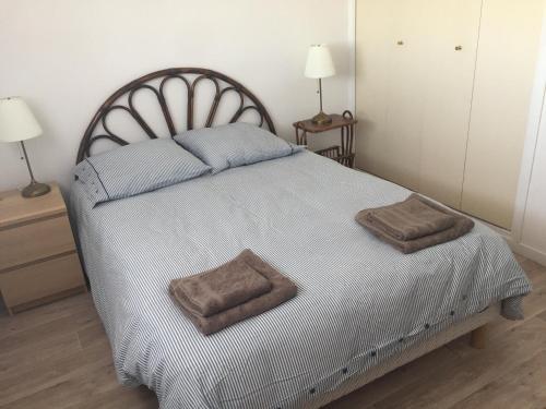 une chambre avec un grand lit avec deux oreillers dessus dans l'établissement boulhome, à Boulouris-sur-Mer