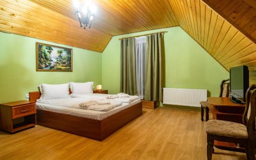 a bedroom with a bed and a desk and a television at Готельний комплекс Парламент, Яблуниця in Yablunytsya